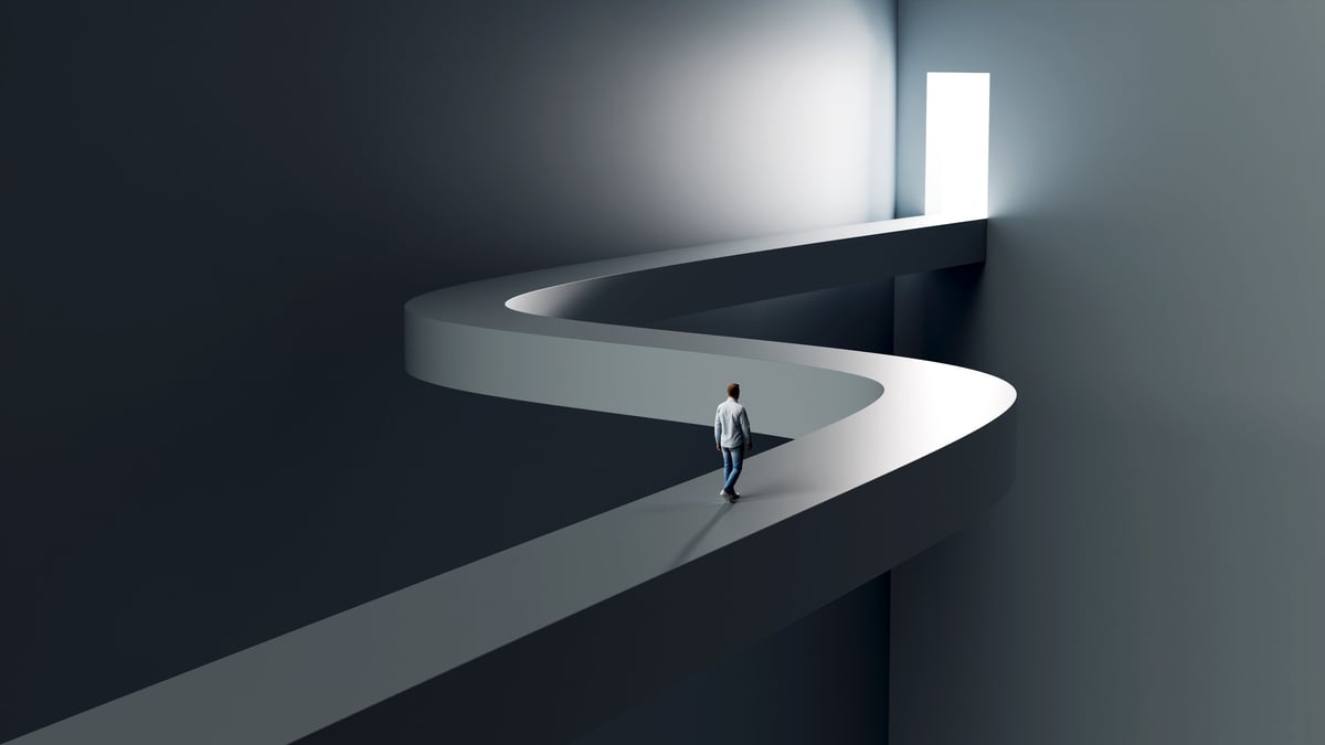 A man walking toward a bright doorway representing the transformative journey of a new beginning